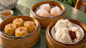 Siu mai, shrimp dumplings, and white pork buns on separate serving dishes