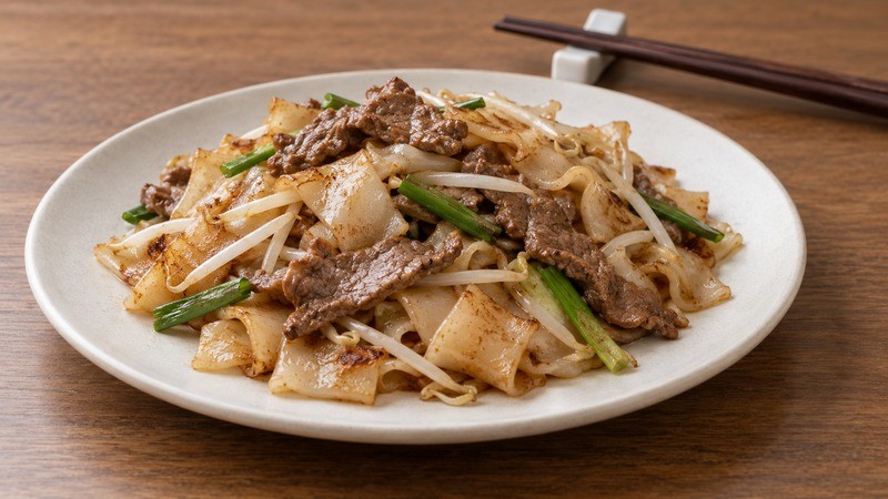 Dry-style beef chow fun showing wide rice noodle ribbons without pooled liquid