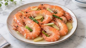 Cooked shell-on shrimp with ginger slices and scallions in a little clear cooking liquid