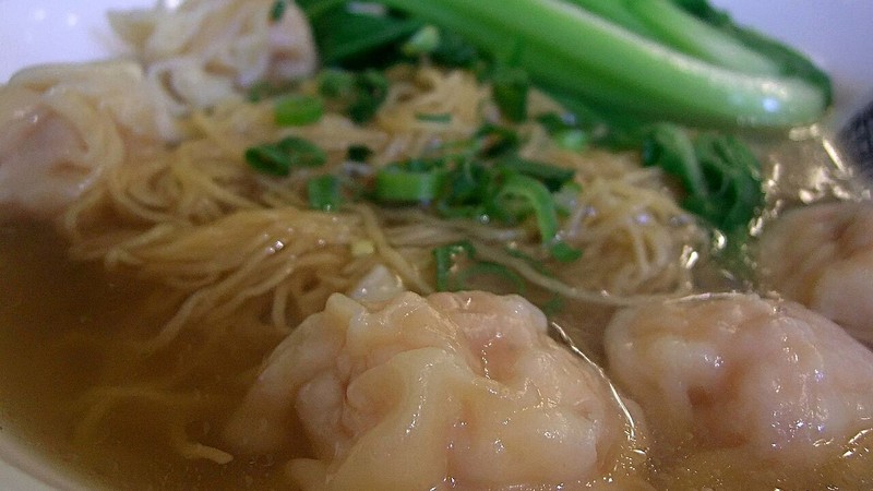 Wontons and leafy greens in a noodle-soup bowl