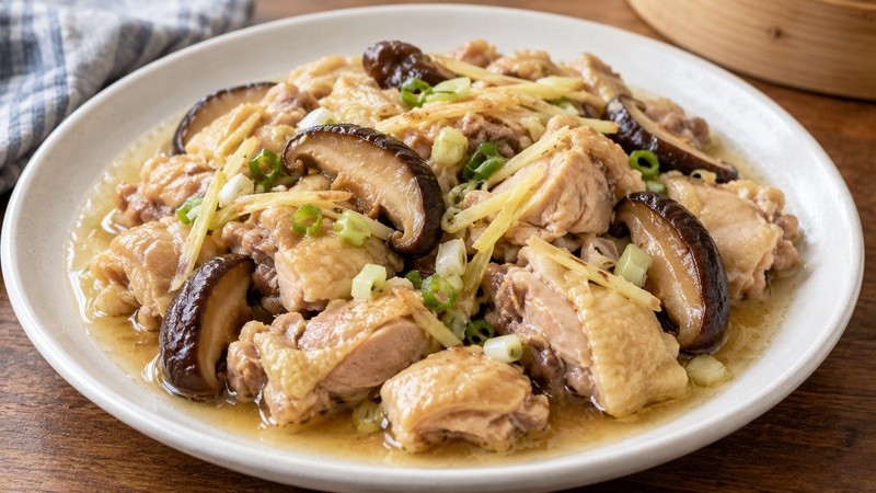 Steamed chicken with shiitake mushrooms on a shallow plate