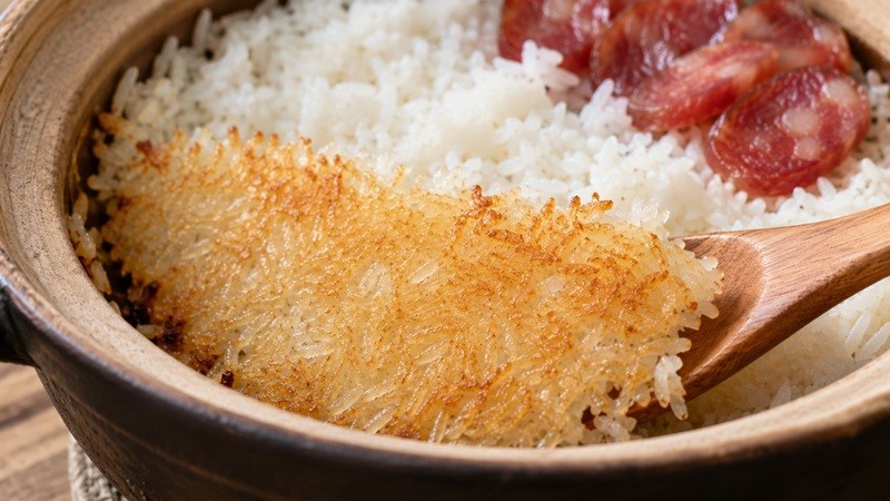 Golden rice crust lifted from the bottom of a clay pot