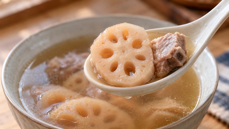 Spoon lifting a lotus-root slice and tender rib