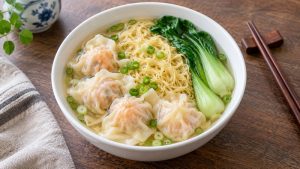 A finished bowl of Cantonese wonton noodles, clear broth, pork shrimp wontons and bok choy
