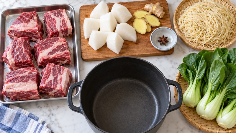 Brisket, daikon, ginger, noodles, and greens prepared for four soup bowls