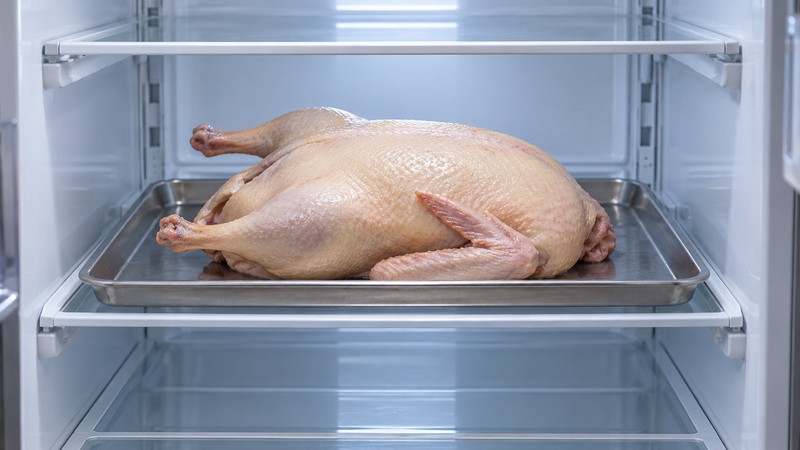 Coated duck drying uncovered on a tray in the refrigerator