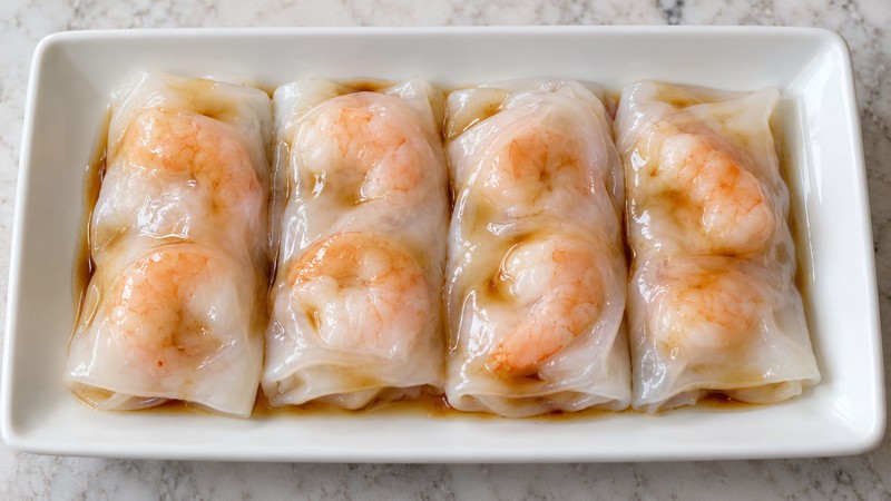 Cooked shrimp wrapped in translucent steamed rice rolls with light soy sauce