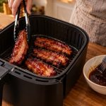 Cook turning and glazing char siu strips in an air fryer basket