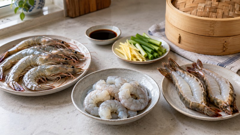 Shell-on, peeled, and split-back shrimp arranged with ginger, scallions, and a bamboo steamer
